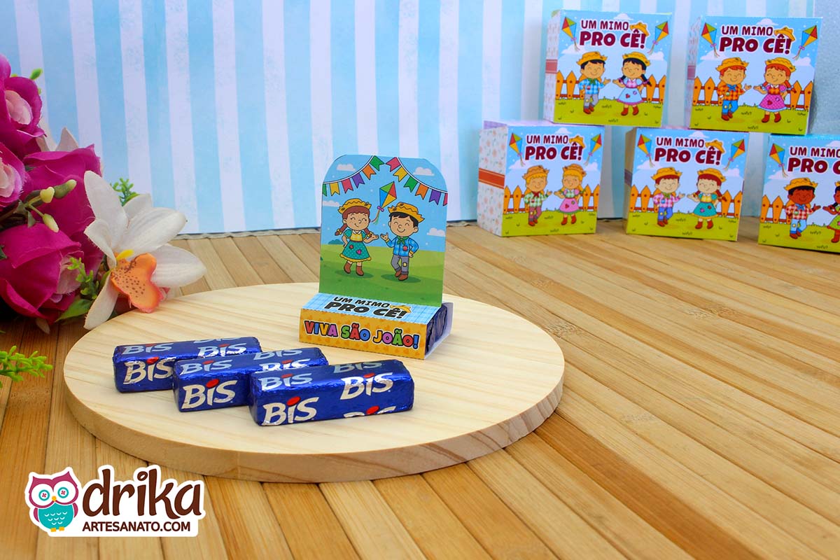 Porta Bis Junino com caipira de cabelo castanho e caipira de cabelo preto em base de madeira com chocolates
