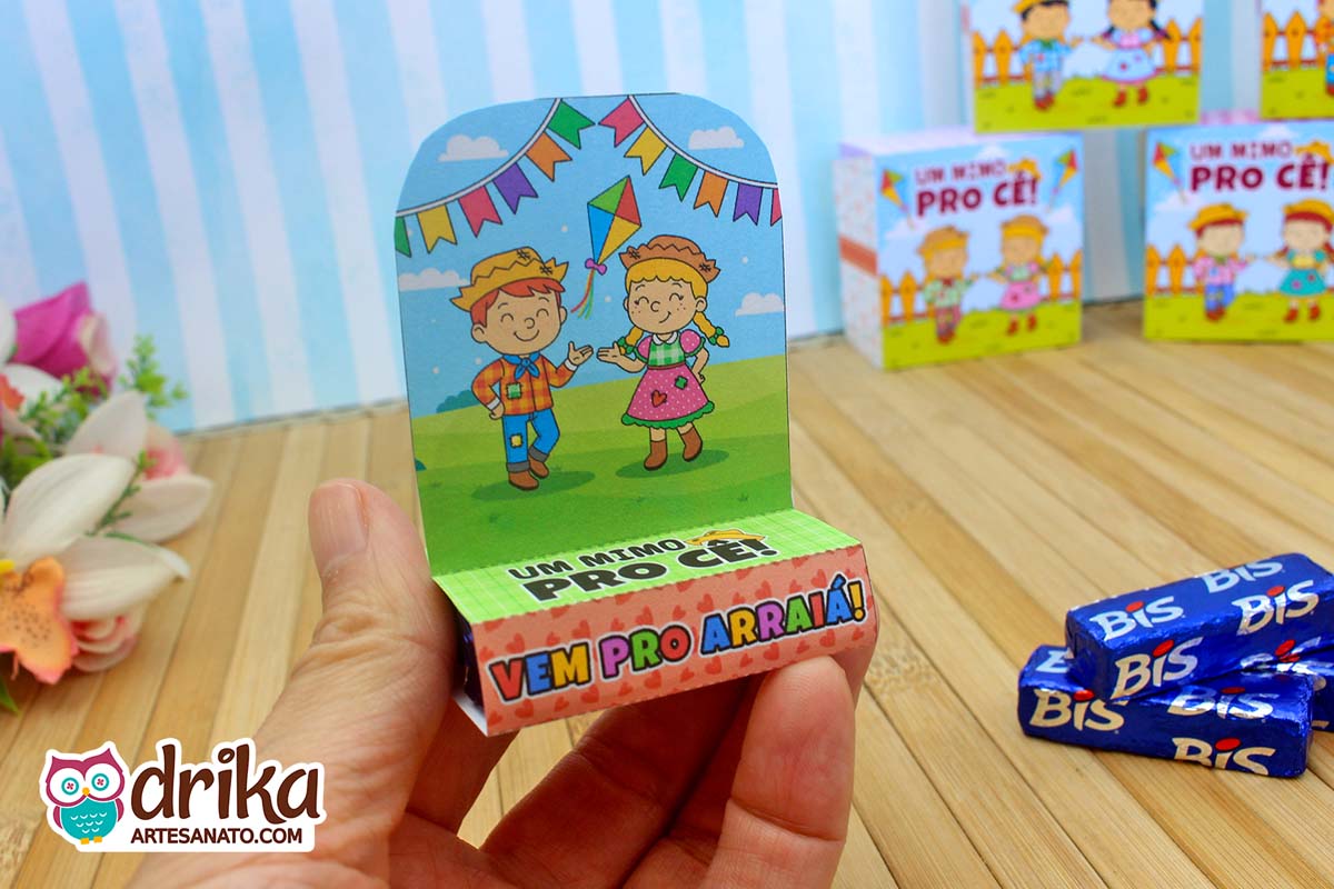 Porta Bis Junino com caipira ruivo e caipira loira na mão, com frase "Vem pro Arraiá"